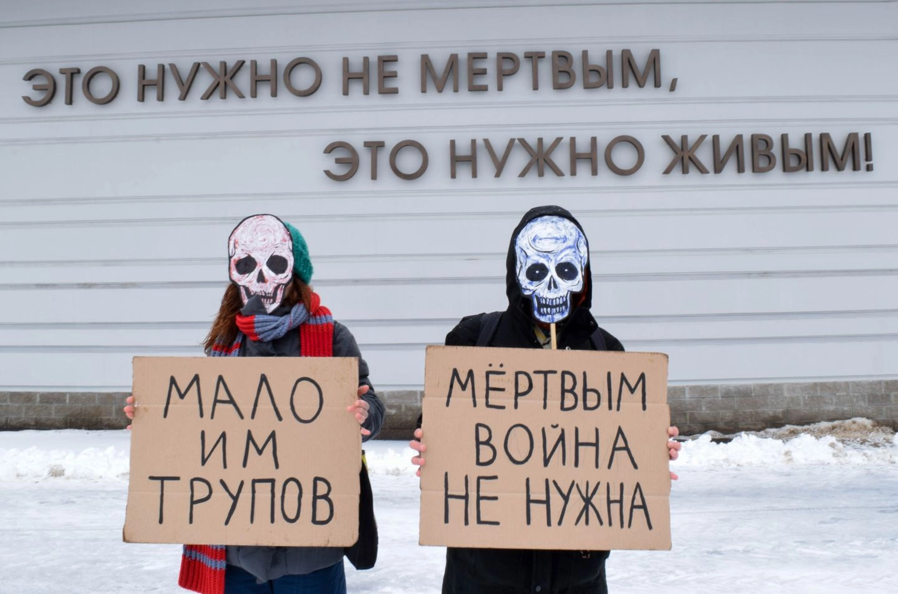 (In the background) "The dead do not need this. The living do." (Signs) "Too few corpses." "The dead don't need war."