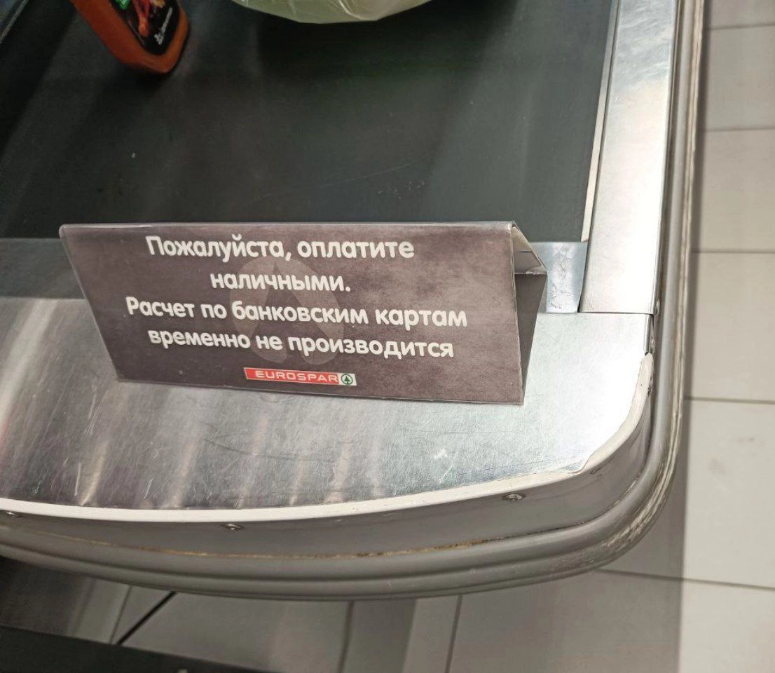 A sign at a checkout counter at the EUROSPAR supermarket chain reads “Please pay in cash. Bank card transactions are temporarily unavailable.”